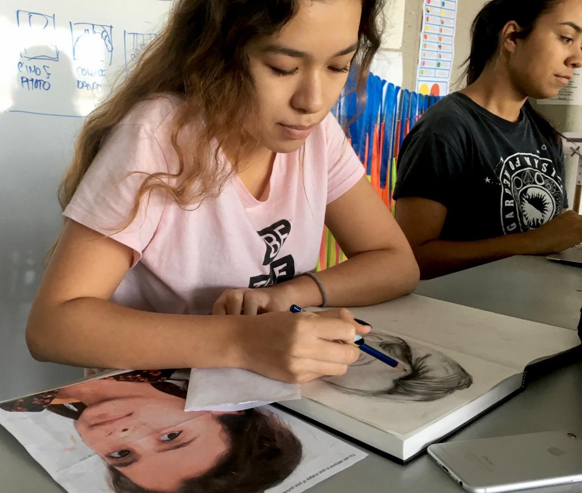 Junior Day El-Wattar sketches a young refugee girl from Syria. When completed, the work will be sent to the child through the Memory Project.