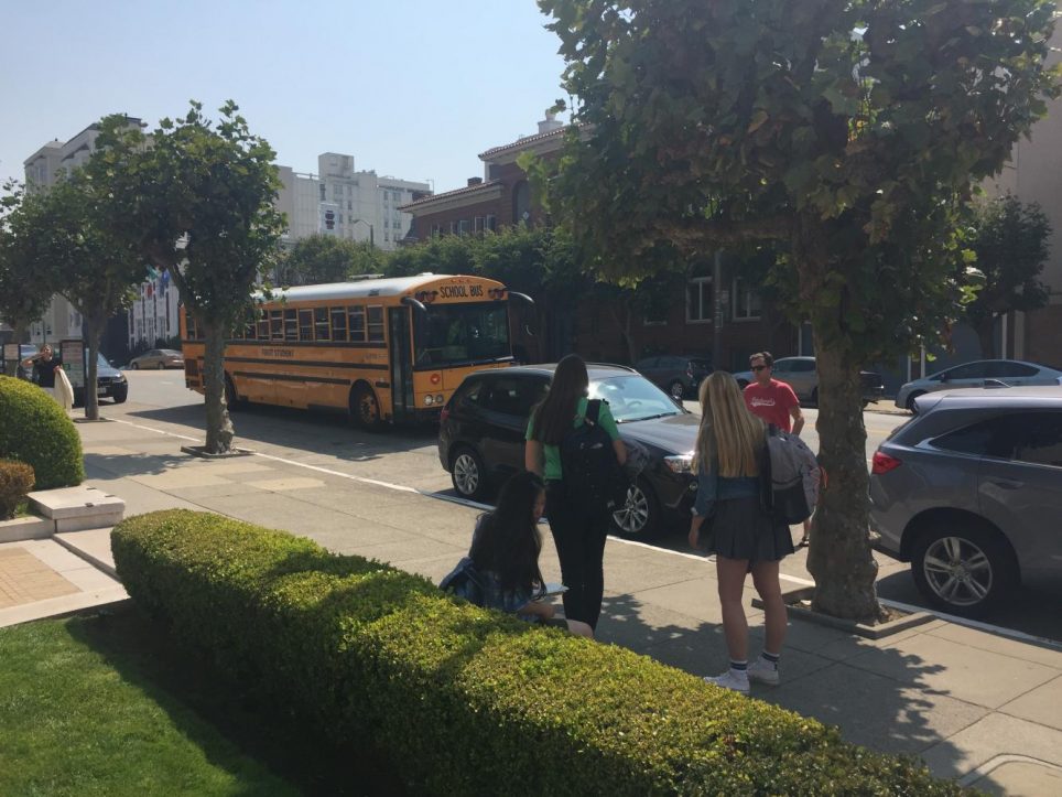 Students wait to board the school bus to Stuart Hall. Buses on the first few days of school were completely filled, which caused many students to have to wait for a second bus to come.
