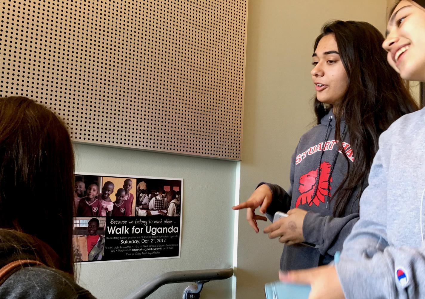 Sophomores Caroline Thompson, Isabelle Paul and Colette Hom read the Walk for Uganda informational poster and talk about their plans to support the schools in Uganda. These girls, among others, decided to “Sleep in for Uganda” and will donate without going to the event.