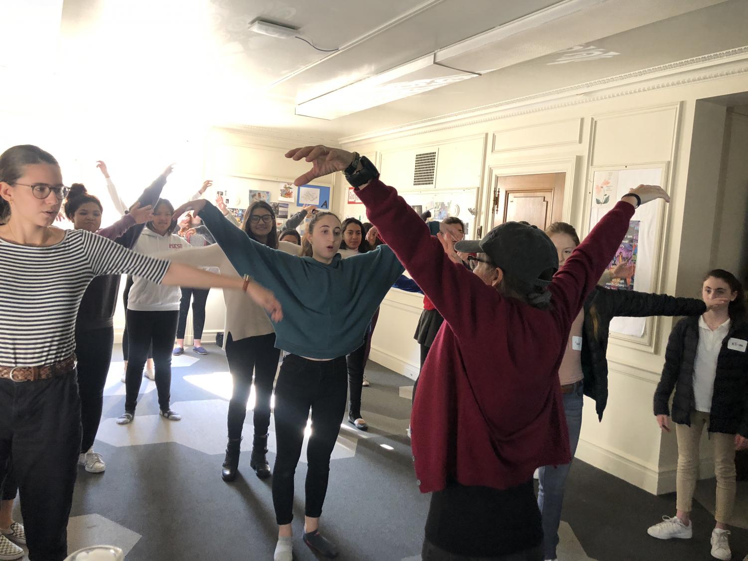Theology teacher Katherine McMichael leads her sophomores through a QiGong movement. The practice focused on taking energy from the five elements on Earth, and is said to allow energy to flow through the body.