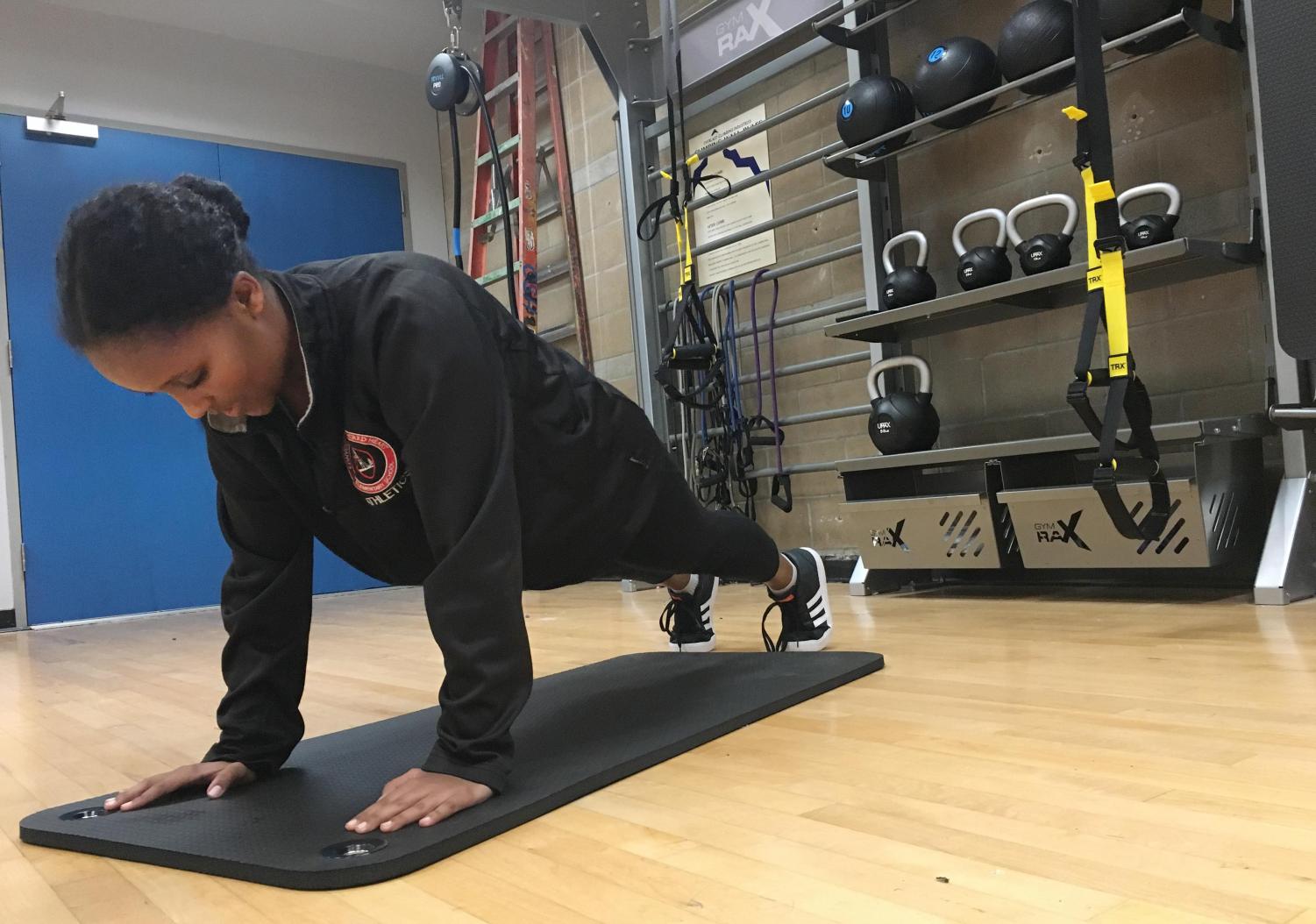 Senior Edna Tesfaye holds a plank in the newly redone multi-purpose room. The conditioning session alternates between the two reconstructed training rooms.