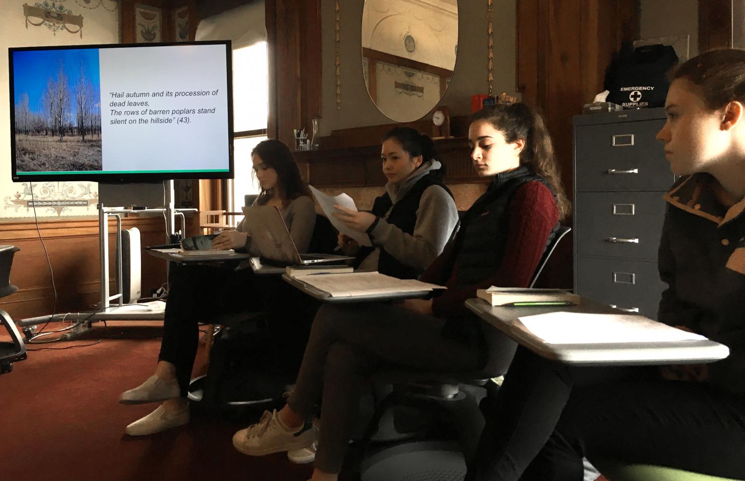 Juniors Hannah Kelliher, Mason Cooney, Emily Kanellos and Laura Mogannam (left to right) analyze a quote during their Interactive Oral Presentation. Their topic explored the significance of music and food in Vietnam, focusing on the novel