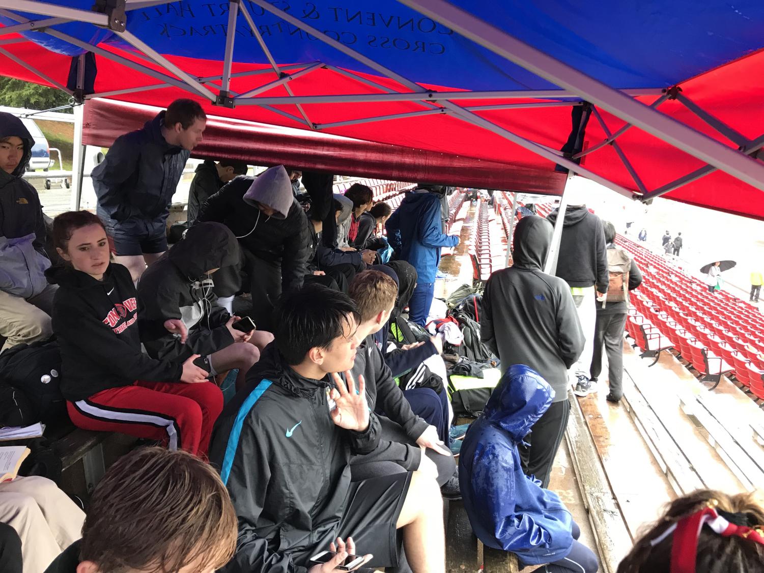Athletes sit under the team tent to protect themselves from the rain while watching the races. The rain stopped in the late afternoon.
