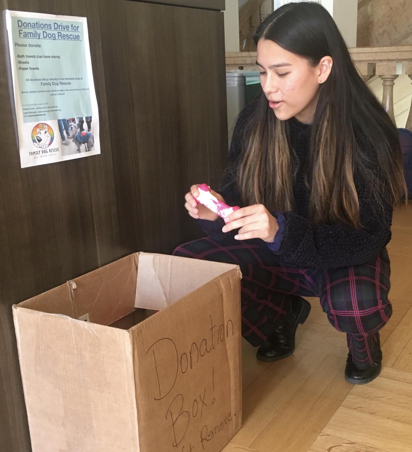 Junior Kira Daley donates a dog toy to the Family Dog Rescue drive. There are boxes placed in the Center, Gallery and 2nd floors' Siboni hallway.