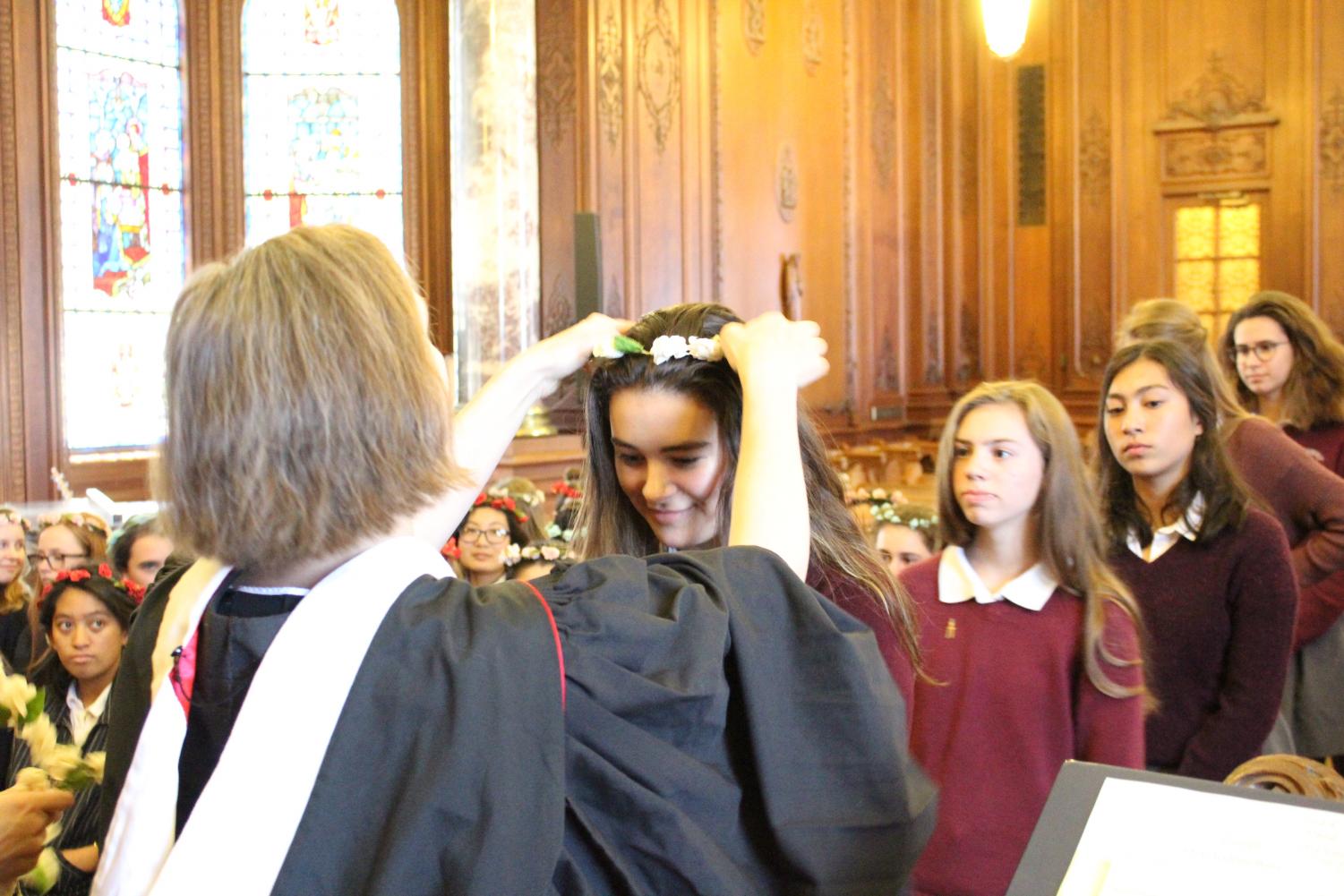 Head of School Rachel Simpson places a floral wreath on the head of sophomore Kate Hindley during the 131st annual Prize Day ceremony. Each student received an award signifying the completion of their academic year.