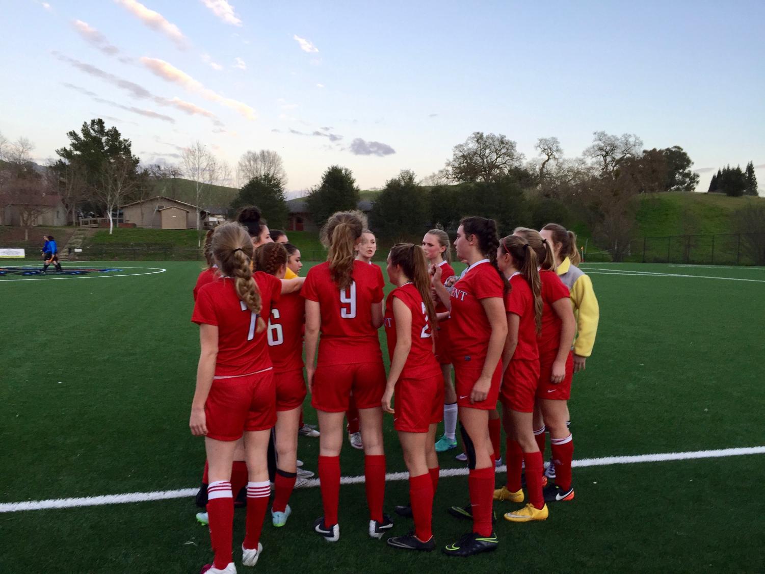 The soccer team huddles before a game last year. The season has been moved from spring to winter.