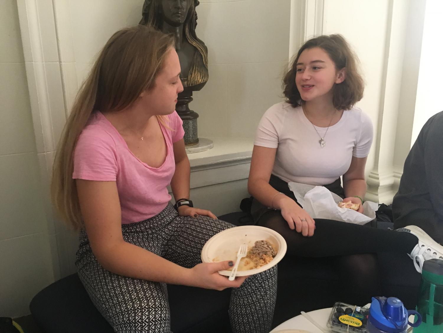 Seniors Delaney Tobin and Camilla Sigmund eat lunch in the main hall while dressed in pink clothing to celebrate 'Mean Girls' day. The day is celebrated in honor of the 2004 hit film and is recognized by fans across the globe.