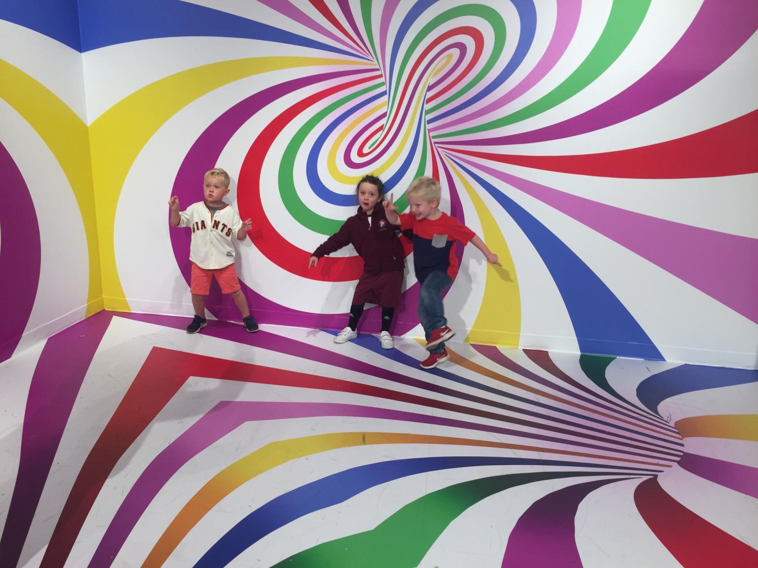 Faculty children Sebastian Galringhouse and Isla Abbott play with their friend Elliot Stewart-Kahn in one of Candytopia's installations. The museum opened on Sept. 6 and aims to be an engaging place for all ages.