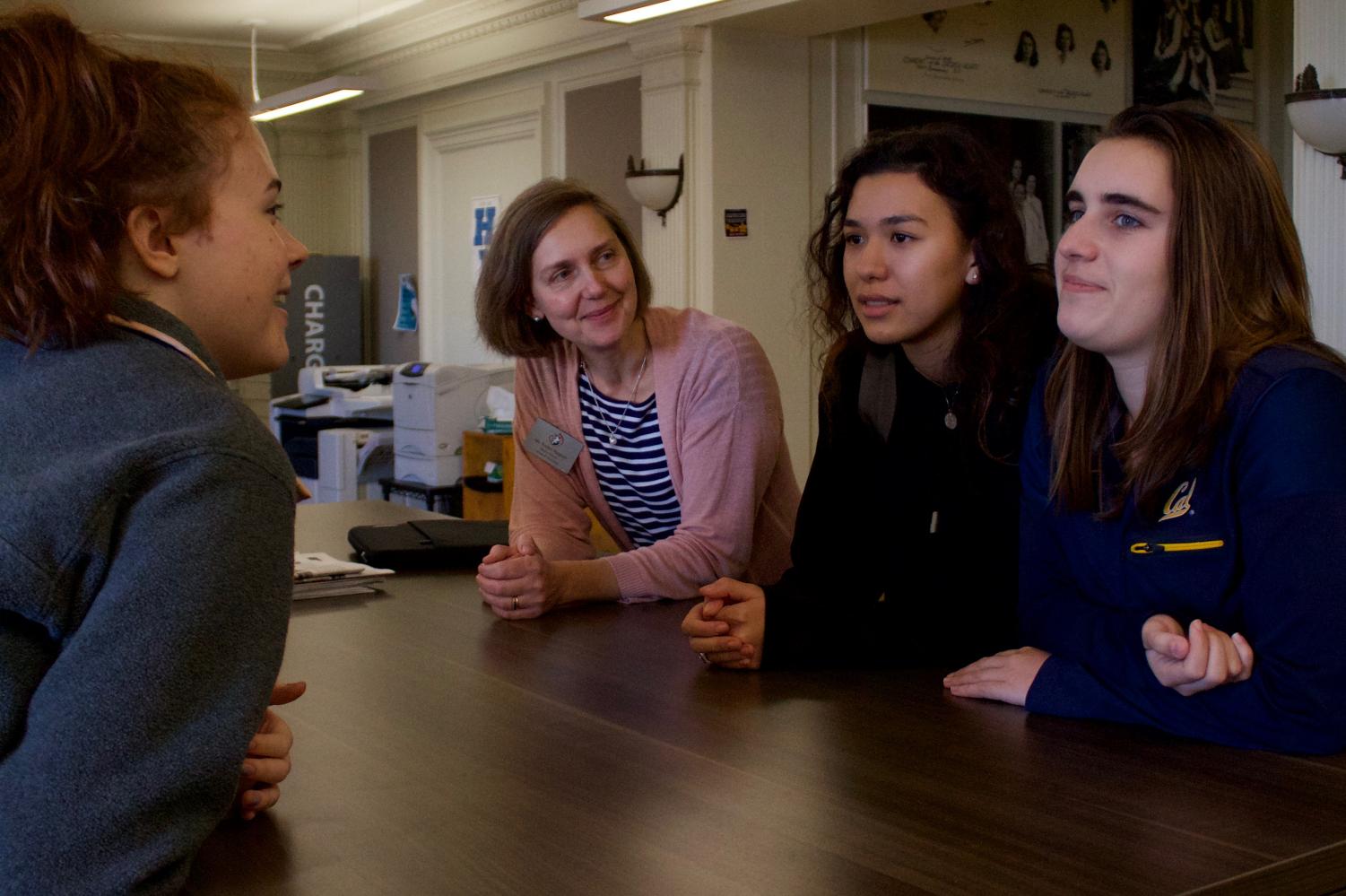 LEAN IN Head of School Rachel Simpson converses with seniors Laura Mogannam, Kate Etter and Day El-Watter outside her office in The Gallery after school. Simpson is being recognized nationally for encouraging students to express themselves across all academic areas including written word, student government, art shows and student-initiated events.