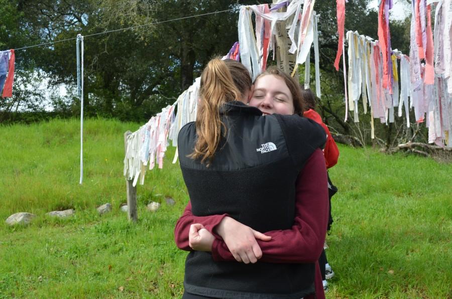 Seniors Sarah Hegarty and Brooke Thomas take a moment to embrace one another at the Peace Pole in Bishops Ranch.  SOPHIA REDFERN | The Broadview