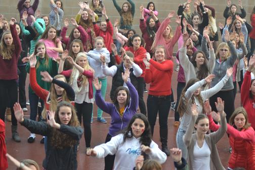 Junior Dani Hogan and freshman Corinne Sigmund (center) dance with the student body as a part of the One Billion Rising movement today. The V-Day event raised awareness for abuse against women.