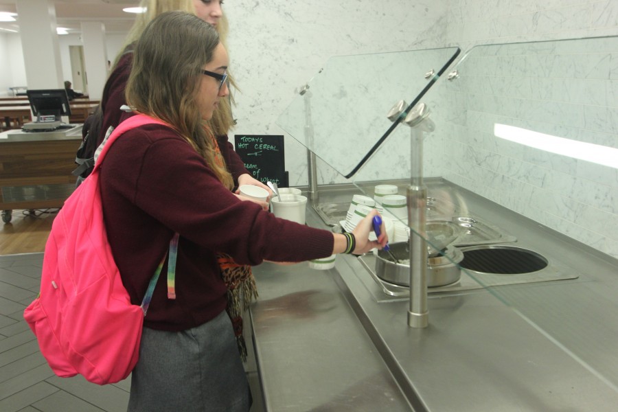 Sophomore Rebecca Stapleton serves herself oatmeal — a new self-serve option in the cafeteria — before her first period class. Students can also get a pancake breakfast on Tuesdays and Thursdays.