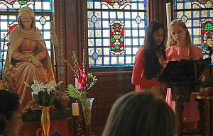 Freshmen Asha Khanna and Lily Niehaus open yesterdays prayer service for the Feast of Mater Admirabilis with the Call to Prayer. The statue is a likeness of the fresco in Rome, painted in 1844 by Pauline Perdrau.