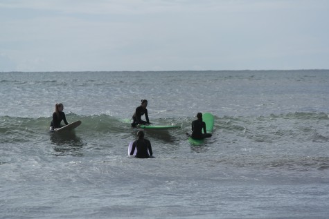 Senior Alanna Hu (top left) sits on her board as she waits to catch a good wave into Bolinas Beach with junior Serafina Cinti (left) and sophomore Grace Apple. The newly-formed Surf Club has weekend excursions with moderator Pascal Parra who instructs club members on form and assists in getting students familiar with the sport.