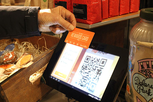 Steve Nuzzo scans the QR code on the back of his SpotOn card to earn re- wards at the Dolores Park Cafe. Retailers are moving away from punch cards to digital loyalty programs.