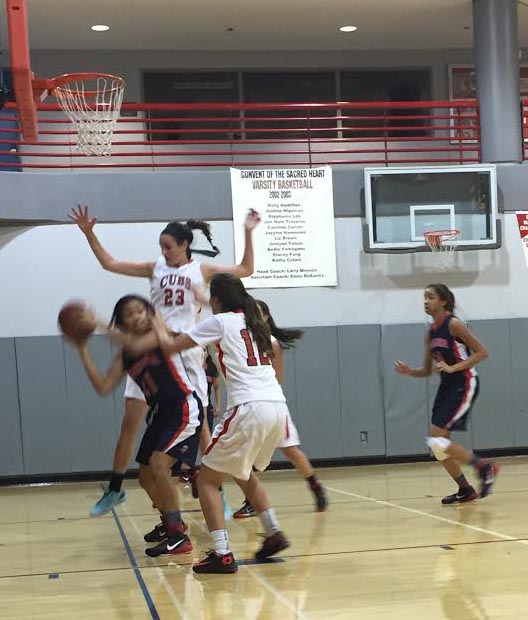 Ariana Abdulmassih jumps while defending the ball from a University High School player with help from teammate Alyssa Alvarez on Jan. 13. The Cubs are 4-3 in league standings. Photo: Fiona Mittelstaedt/The Broadview