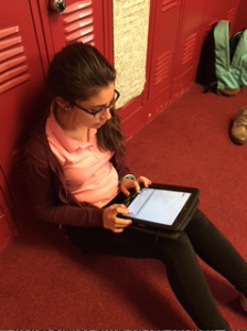 Freshman Carlota Rubio reviews her poem after she submitted it.