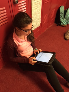 Freshman Carlota Rubio reviews her poem after she submitted it.