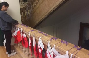 Sophomore Activities Director Jilan Powers ties secret santa stockings to the marble stairs after school today. Students were advised to not spend over $5 per gift, although are allowed to if they choose.