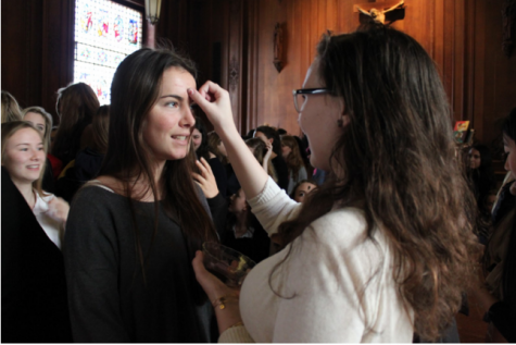 Sophomore Lucia Escalza receives ashes on her forehead from senior Maxine Hanley. The Ash Wednesday chapel included scripture reading and student testimonials. 