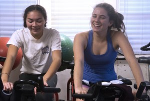 Juniors Hailey Long and Katie Newbold (left to right) cycle during winter conditioning practice. Ahletes also weight lift, run and do core exercises.