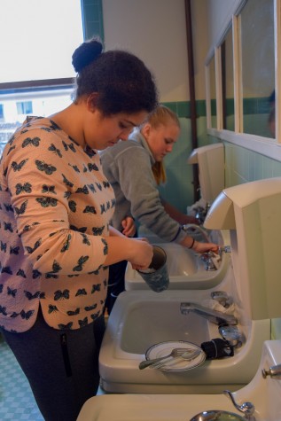 Sophomore Lulu Desai scrubs the second floor bathroom in the Flood Mansion during Community Service Day. Students helped to clean all areas of the school in order to show their appreciation for the janitorial staff.