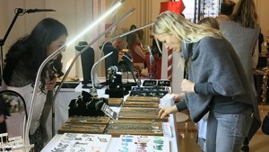A woman inspects a necklace at
a boutique during the Christmas on Broadway fundraiser. Local
vendors donate a portion of their proceeds to the Schools.