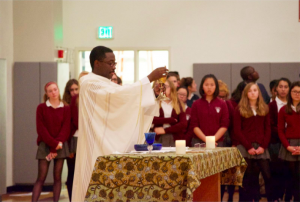 The Rev. Paul Zirimemya blesses the wine during the Holy Eucharist at the All Saint’s Day mass. Catholics celebrate All Saints’ Day annually to commemorate the saints of the church who have died. 