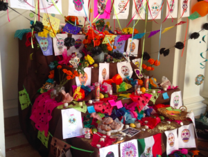 A Day of the Dead altar made by Convent Elementary students stands in the Main Hall commemorating those who have died. Others wrote down the names of those they would like to honor on a sticky note and placed it on the altar.