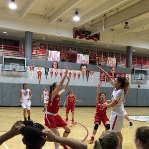 Senior Alyssa Alvarez makes a shot while fellow teammates watch from the bench during the Varsity Senior Night game against University. This story was updated with a photo from the February 7 game.