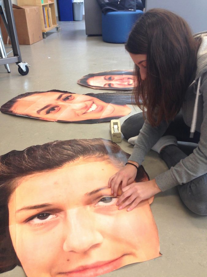 Varsity basketball player Kiki Apple finishes posters, each the face of a senior on the team, for Senior Night in the art room. The posters were hung next to each player’s name and number in the gym.