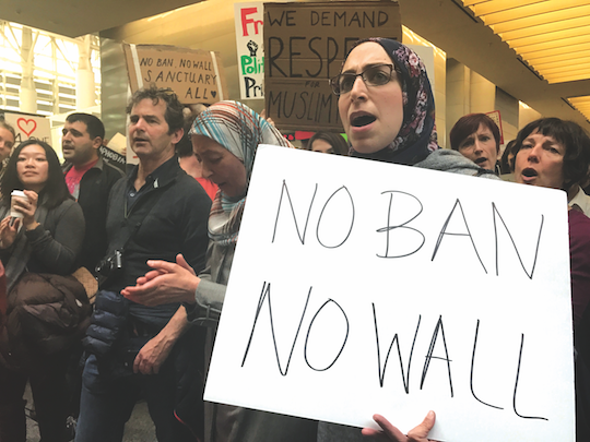 Muslim-American protestor Asmaa Mourad stands with her mother Nihad Mourad repeating a series of chants in the international terminal of San Francisco International Airport. Some protestors made camp in the terminal from the night before and distributed free food, beverages and feminine hygiene products to all attendees. 