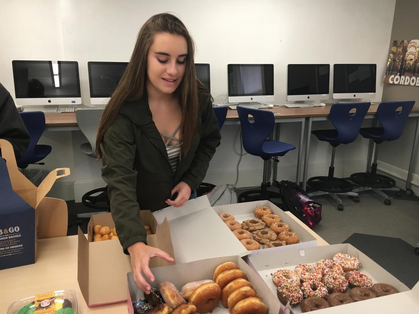 Sophomore Kate Etter reaches for a doughnut during the Computer II class’s end of the semester party. The class chatted about their plans for summer during the period. 