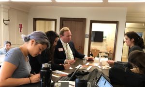 Seniors Marguerite Williamson (right) talks to Syracuse University representative Peter Hagan (center) while Sinead McKeon (right) and juniors Darren Loy and Sofia Pirri (left) fill out papers. Hagan was the first representative to visit this school year.