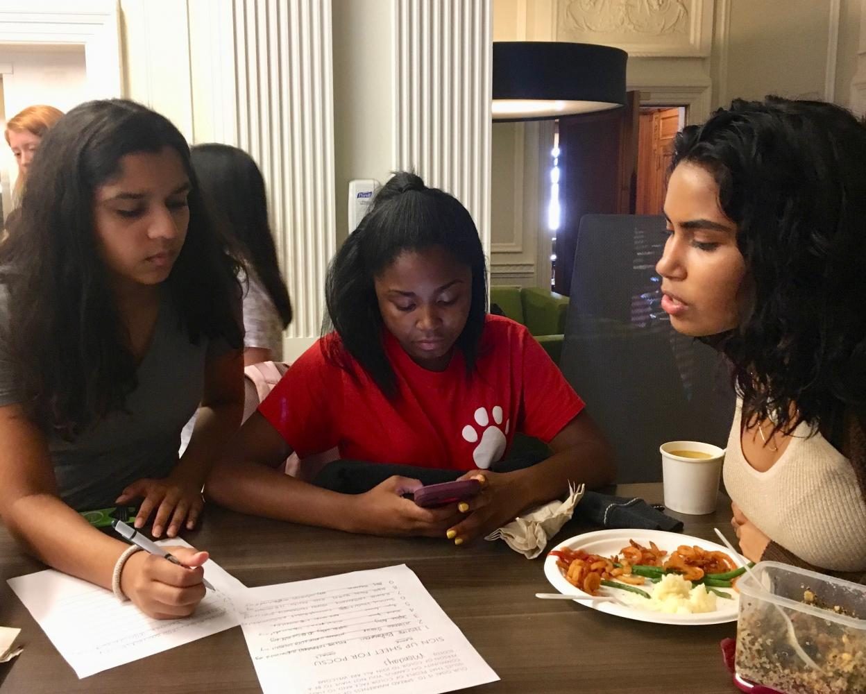 Jade Despanie and Malinalli Cervantes represent POCSU at the club fair in the Center on Tuesday as Avani Mankani signs up. POCSU was one of the 28 clubs represented at the fair.