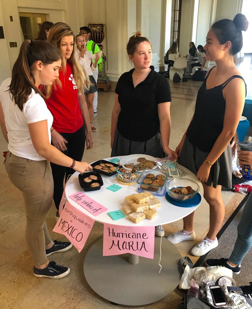 Senior and club head Erika Wong hands discusses Hurricane Irma with seniors Rosie Morford, Candice Weinman, and Grace Ainslie. All profits made at the bake sale will be donated to Unicefs disaster relief organization. 