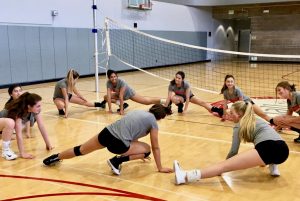 The Varsity Volleyball team stretches together to prepare for practice after having the past several days off. The team as well as all other school related sports, resumed practices  as normal today after school. 
