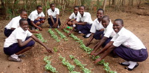 Girls from the agricultural club at Kangole Senior Secondary School pose with the beginnings of their greenhouse project. The club is responsible for maintaining the project, which is one of the efforts that the school has initiated in an effort to become self-sustaining.