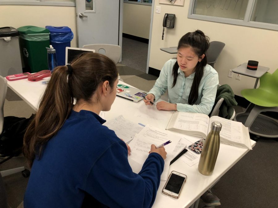 Senior Halie Kim helps senior Guilia Oltranti during peer tutoring session. The students in the room worked with each other as well as with Kim during the tutoring session.