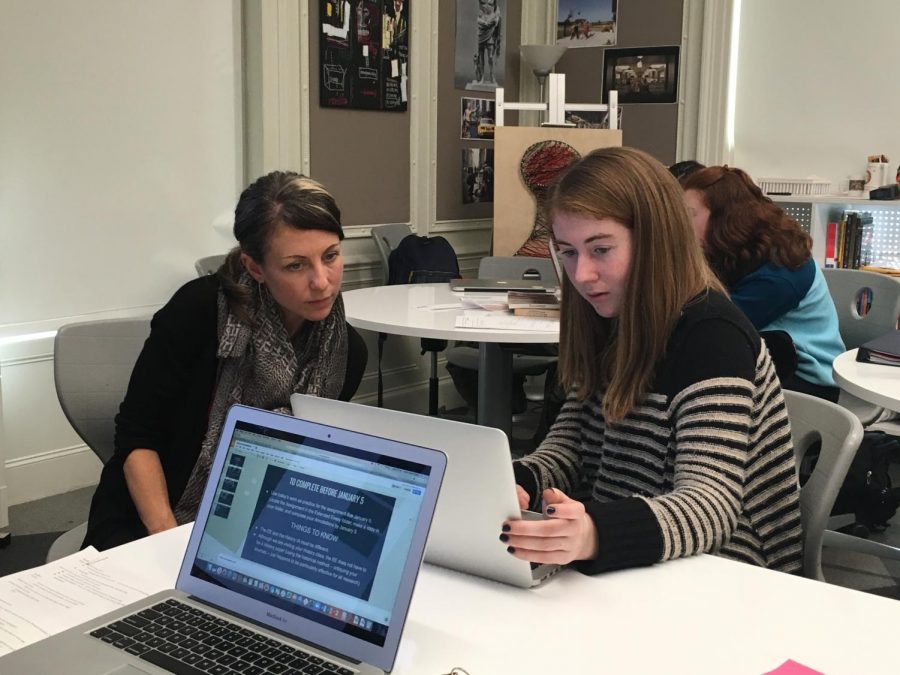 Extended Essay Coordinator Alyson Barrett-Ryan assists junior Sophie Egan with her extended essay. Students's subject areas and initial research questions were due Monday.