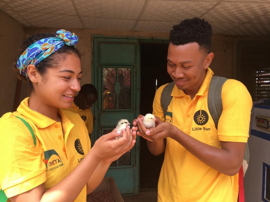 Alumna Bianka Quintanilla-Whye and teammate Paul Watkins hold newly-born chicks hatched in poultry farmer Boureima Kabres traditionally-powered incubator in Burkina Faso. Their team from Stanford University worked in Kabres shop assembling a solar powered incubator they designed.