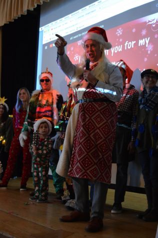 History teacher Michael Stafford lip-syncs during the advisor costume contest. Stafford, along with numerous other advisors, were dressed up by their advisees as Christmas-related figures as a part of the four-hour holiday celebration.
