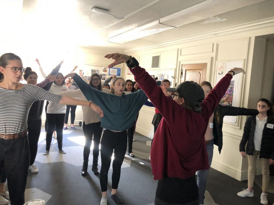 Theology+teacher+Katherine+McMichael+leads+her+sophomores+through+a+QiGong+movement.+The+practice+focused+on+taking+energy+from+the+five+elements+on+Earth%2C+and+is+said+to+allow+energy+to+flow+through+the+body.+