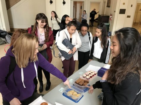 Senior Eden Schade picks out a chocolate chip cookie as club head Erika Wong helps her with the sale. Profits from the sale will be used to buy ingredients to cook meals at the Ronald McDonald House. 
