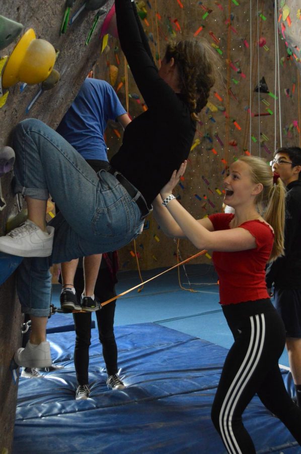 Junior Abby Anderson supports junior Poppy Cohen at a bouldering wall during this years annual Congé. School buses transported students to Bladium Sports Center in Alameda, CA for a variety of activities.