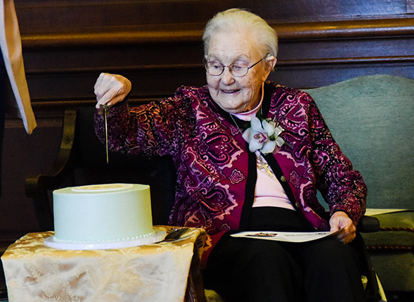 r. Mary Mardel cuts into the cake for her 100th birthday celebration in the Mary Mardel, RSCJ Chapel. The cake was covered in mint green frosting and featured the original Society of the Sacred Heart seal in yellow on top. 