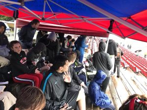 Athletes sit under the team tent to protect themselves from the rain while watching the races. The rain stopped in the late afternoon.