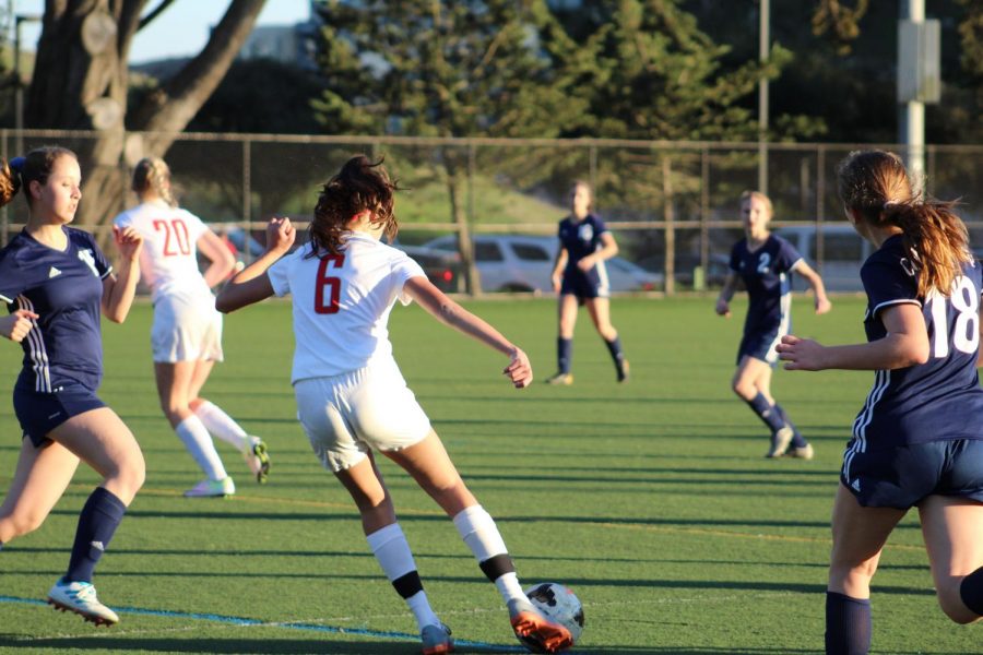 Sophomore Isabelle Thiara dribbles the ball through players from The College Preparatory School during a scrimmage on Feb. 13. The Cubs fell to the Cougars, losing their first scrimmage of the season.