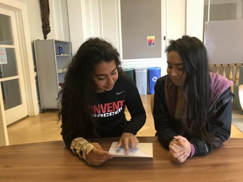 Sophomores Nisrine Rahmoui and Rachel Santamaria look over a poem written by Rahmoui. The annual poetry contest will on Monday April 30th.