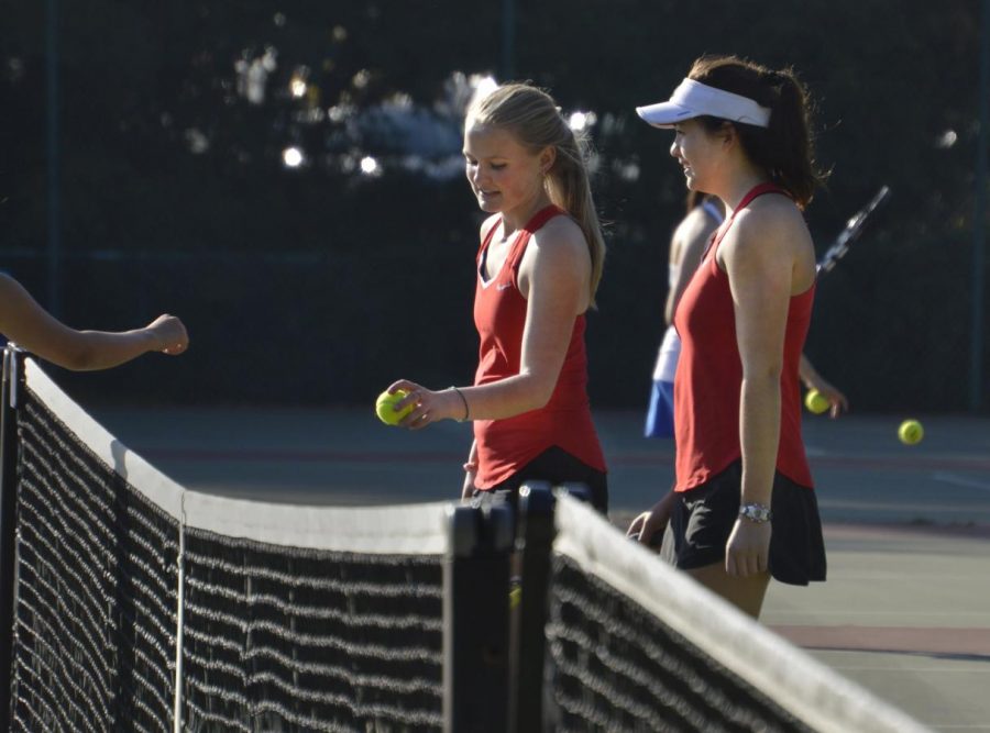 Seniors+Abby+Anderson+and+Mason+Cooney+hand+balls+to+their+opponents+at+the+end+of+a+game.+Both+seniors+have+played+tennis+for+Convent+since+freshman+year.+